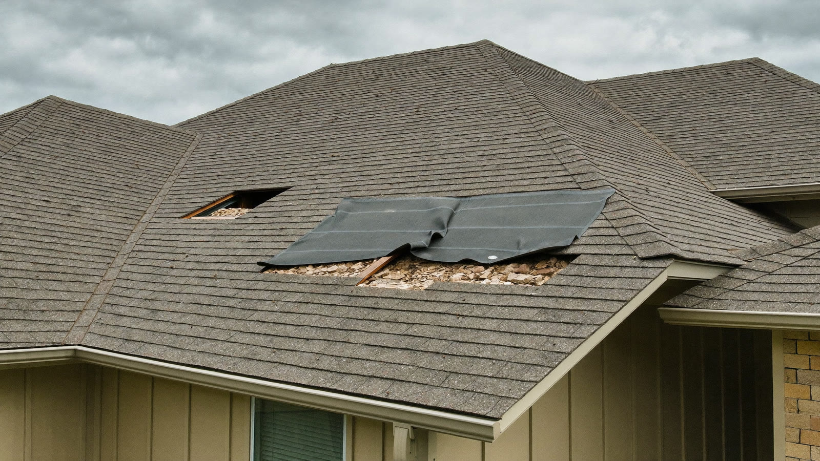 Aging asphalt shingle roof with lifted and damaged shingles